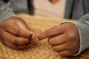 Woman’s hands holding smartphone close-up with ring visible on finger